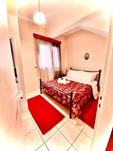 a bedroom with a red bed with a red rug at Feel Home Studio in Mytilene