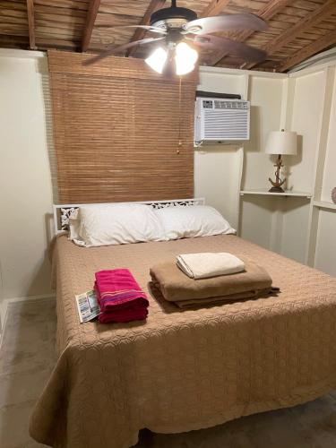 1 dormitorio con 1 cama con 2 toallas en Naniqui Cottage - Only Adults Relax - Only Parking Golf Car, en Culebra