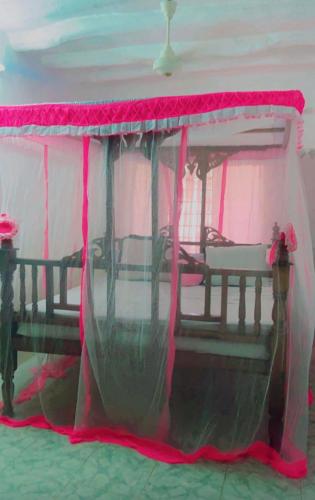 a tent with a table with a pink canopy at Malindi luxury apartment. in Malindi