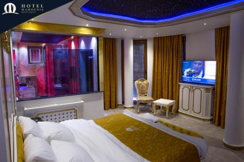 ein Schlafzimmer mit einem großen Bett und einem TV in der Unterkunft Hotel Mamounia Boutique in Pristina
