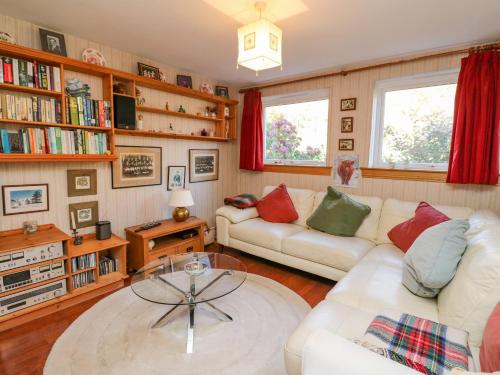 sala de estar con 2 sofás y mesa de cristal en Bourblach, en Mallaig