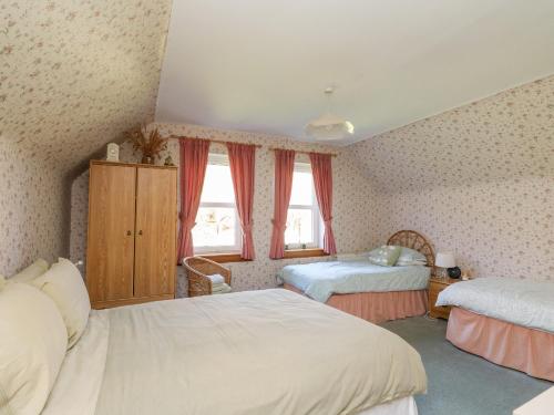 Un dormitorio con dos camas y dos ventanas. en Bourblach, en Mallaig