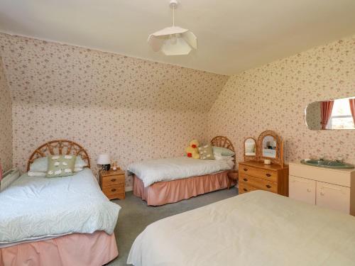 a bedroom with two beds and two mirrors at Bourblach in Mallaig