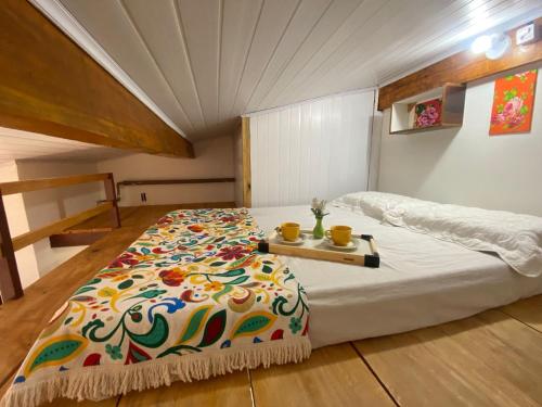 a bedroom with a large bed with a table on it at Casas Vasconcelos in Itacaré