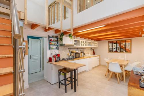 une cuisine avec des armoires blanches et une table et des chaises dans l'établissement Duplex 4 pers. centre avec cour privée ensoleillée, à Marseille