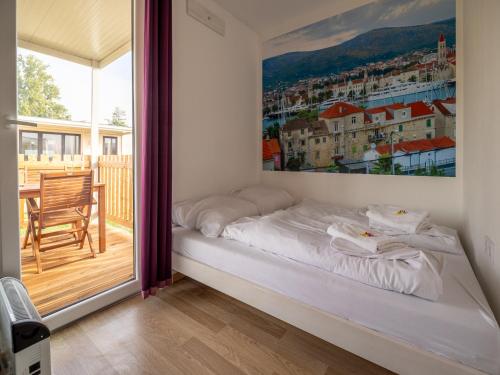チャテジ・オプ・サヴィにあるMediteran Homes with Terme Čatež Ticketsの壁に大きな絵が描かれた部屋のベッド1台分です。