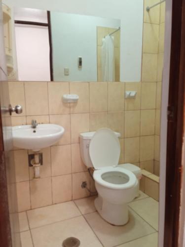 a bathroom with a toilet and a sink at Casa Piscina, Punta Mero in Talara