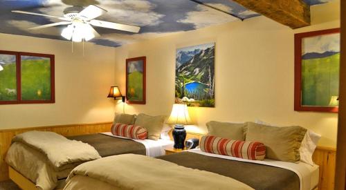 Chewuch Inn & Cabins في نتروب: سريرين في غرفة مع مروحة سقف