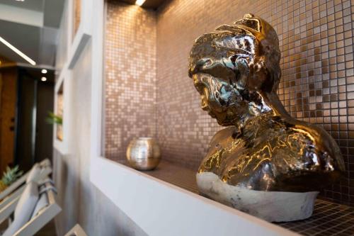 a statue of a person sitting on a shelf at Divina Charme in Mascalucia