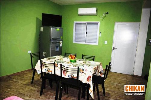comedor con mesa y paredes verdes en CHIKAN Departamentos en Belén