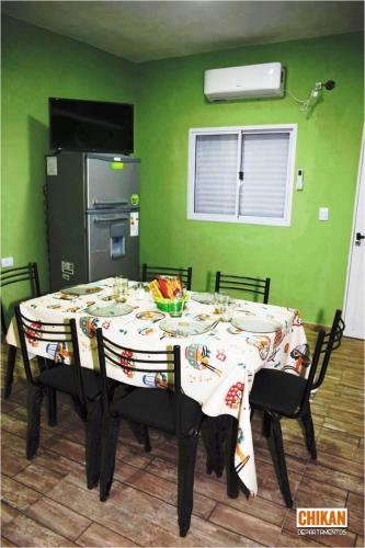 comedor con mesa y pared verde en CHIKAN Departamentos en Belén