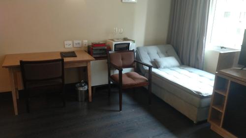 um pequeno quarto com uma cama e uma secretária com uma mesa em A1 Flats Radisson Berrini em São Paulo