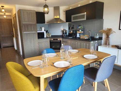 a wooden table with chairs around it in a kitchen at Le Criou - 3 bedroom apartment 5 minutes walk to the village centre in Samoëns