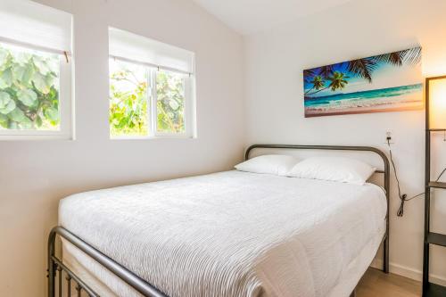 Puni Mauka B 31 plus day rental في Pahoa: غرفة نوم بسرير وملاءات بيضاء ونوافذ