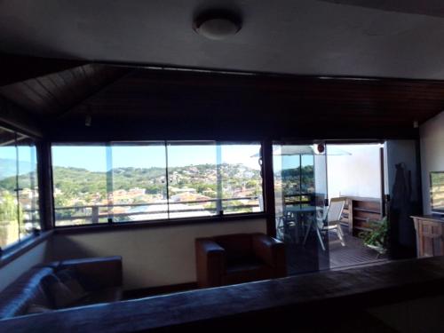 a living room with a large window with a view at Casa em Geribá com piscina e vista para praia in Búzios