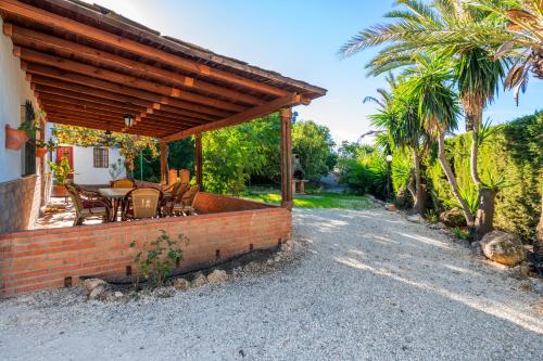 a patio with a table and chairs on a brick wall at Casa La Encina in El Chorro