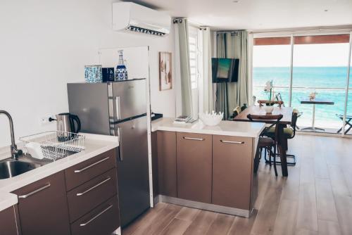 a kitchen with a stainless steel refrigerator and a dining room at PARADISE VIEW 1 bed-room water front studio at Grand Case in Grand Case