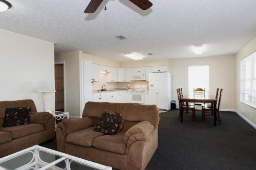 a living room with two couches and a table and a kitchen at Cottages Christian Retreat in Panama City Beach