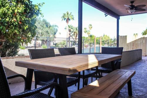 a wooden table and chairs on a patio at Lakefront Hacienda with Pool, Hot-tub, Tennis in Chandler
