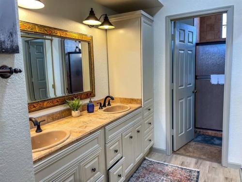 a bathroom with two sinks and a large mirror at Lakefront Hacienda w/ Paddle Boat, Pool, Hot-tub, Tennis in Chandler