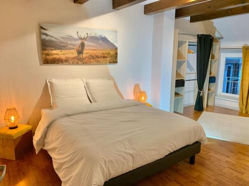 1 dormitorio con 1 cama con una pintura de ciervo en la pared en Le Terrier du Katz, en Dabo