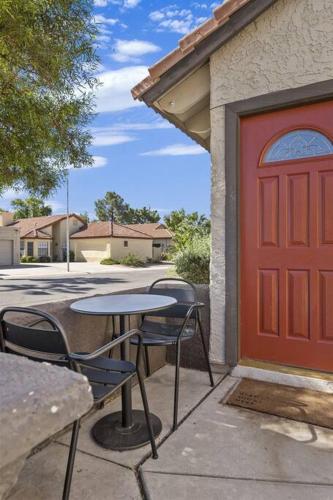 a table and chairs in front of a red door at Studio on the Lake w/ Pool, Hot Tub & Tennis in Chandler
