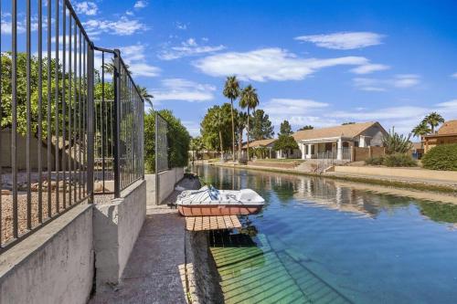 a boat in a canal next to a fence at Studio on the Lake w/ Pool, Hot Tub & Tennis in Chandler
