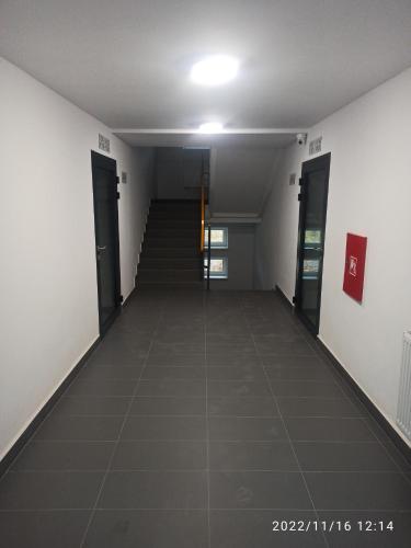 a hallway of an office building with doors and a tile floor at Apartament Magnolia in Warsaw
