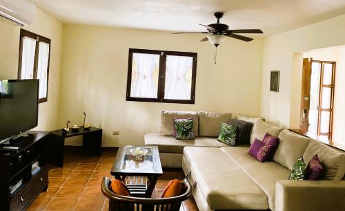 a living room with a couch and a tv at Sueños de Amor! Hermoso y Acogedor lugar in Quepos
