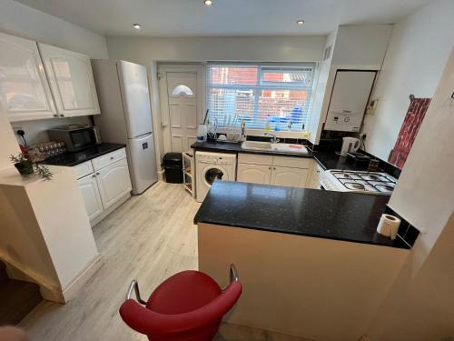 a kitchen with a counter and a red chair in it at Amicable Double Bedroom in Manchester in shared house in Ashton under Lyne