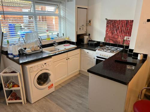 a kitchen with a washing machine and a sink at Amicable Double Bedroom in Manchester in shared house in Ashton under Lyne