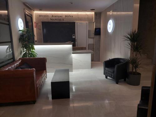 eine Lobby mit Sofas und einem TV in einem Gebäude in der Unterkunft HOTEL BOUTIQUE DOÑA MANUELA in Tomelloso