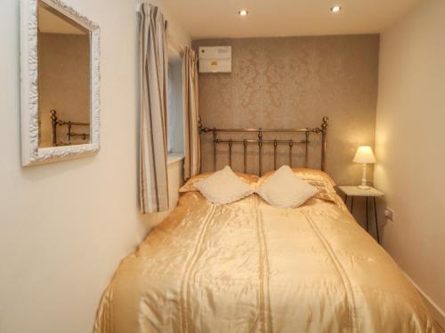 a bedroom with a gold bed with a mirror at The Netty in Buxton