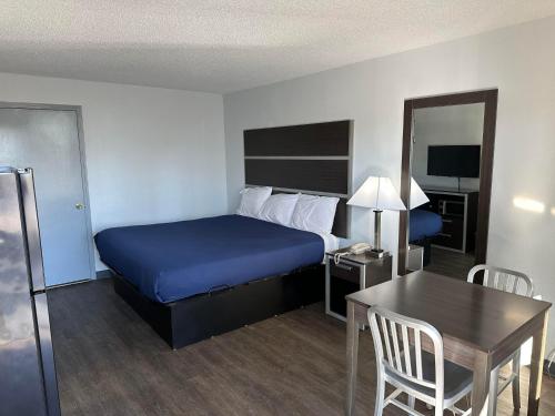 a hotel room with a bed and a desk and a table and chair at Homelodge Newnan in Newnan