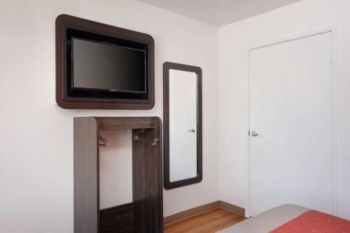 a television on a wall next to a mirror at Motel 6-Arcadia, CA - Los Angeles - Pasadena Area in Arcadia