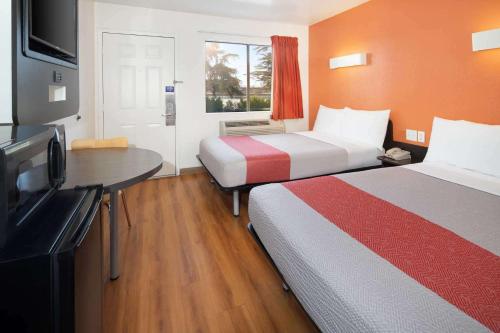 a hotel room with two beds and a flat screen tv at Motel 6-Arcadia, CA - Los Angeles - Pasadena Area in Arcadia