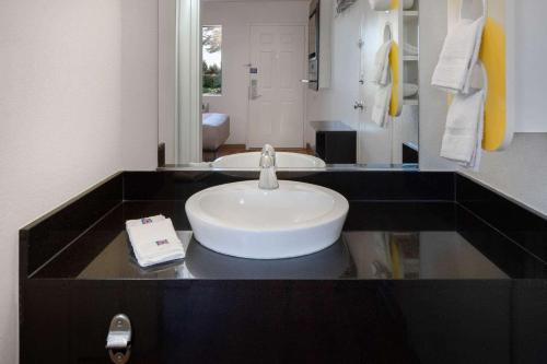 W łazience znajduje się biała umywalka i lustro. w obiekcie Motel 6-Arcadia, CA - Los Angeles - Pasadena Area w mieście Arcadia