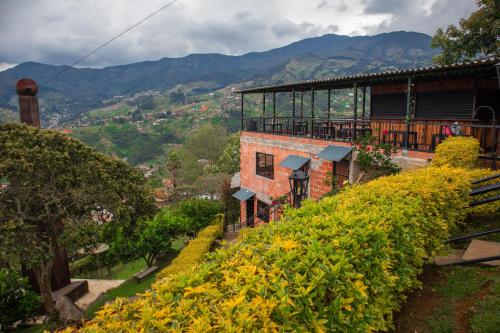 a building on top of a hill with bushes at Casa de Arte Monte Sinaí in Medellín