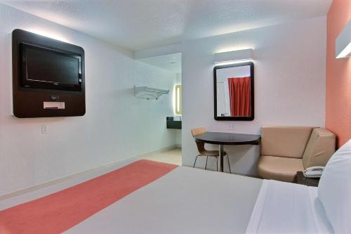 Habitación con cama, TV y mesa. en Motel 6-Corpus Christi, TX - East - North Padre Island, en Corpus Christi