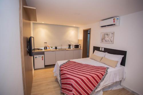 Un dormitorio con una cama con una manta a rayas. en Bauten Cabo Branco 206 - completo, 150m da praia, en João Pessoa