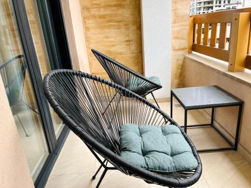a black chair sitting on a balcony with a table at Apartmani SLEEP&JOY in Zlatibor