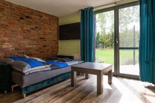 sypialnia z łóżkiem i ceglaną ścianą w obiekcie Ranczo Dolidki w mieście Gwieździn