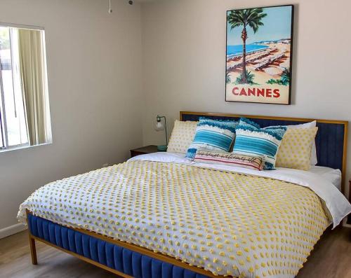 um quarto com uma cama com um edredão azul e amarelo em Newly Remodeled Mid Century Saguaro House (36) em Phoenix