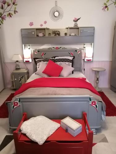 - une chambre avec un grand lit gris et des draps rouges dans l'établissement Maison cocoon et chaleureuse, à Marcilly-sur-Seine