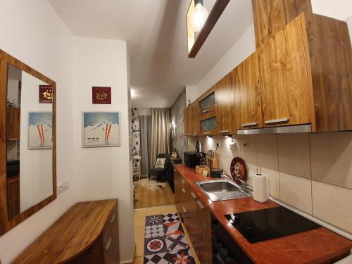 a kitchen with wooden cabinets and a sink at Pinewood ANG Apartment, Semiramida Borovets Hills in Borovets
