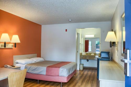 Habitación de hotel con cama, escritorio y espejo. en Motel 6-Seattle, WA - South, en SeaTac