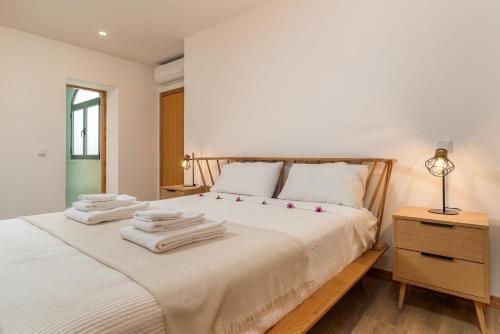 um quarto com uma cama com toalhas em Casa Paul do Mar em Paul do Mar