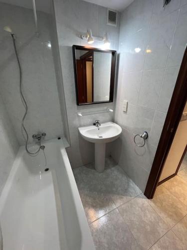 a bathroom with a sink and a mirror and a tub at Riviera Mont Roig Del Camp in Tarragona