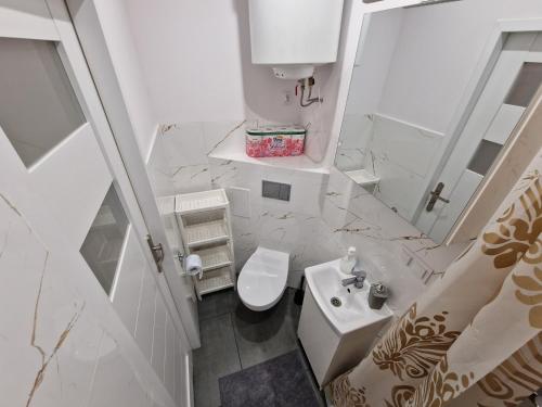 a white bathroom with a sink and a toilet at Apartamenty w pełni wyposażone w CENTRUM MIASTA in Inowrocław