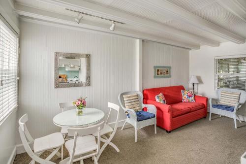 a living room with a red couch and a table at Cannon Beach Hotel Collection in Cannon Beach